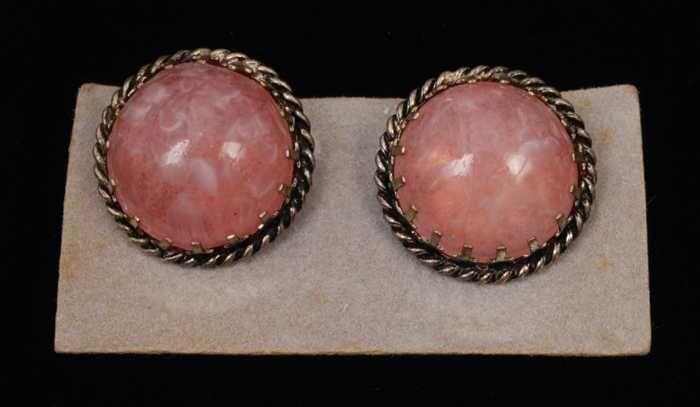 Paar oorbellen, clip met ronde halfbolle roze glazen knop in zilverkleurige vattin, op grijs…