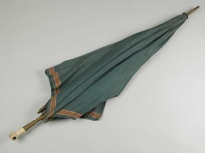 Paraplu met bekleding van groen-blauw katoen koperen steel, benen handvat in de vorm van een vuist