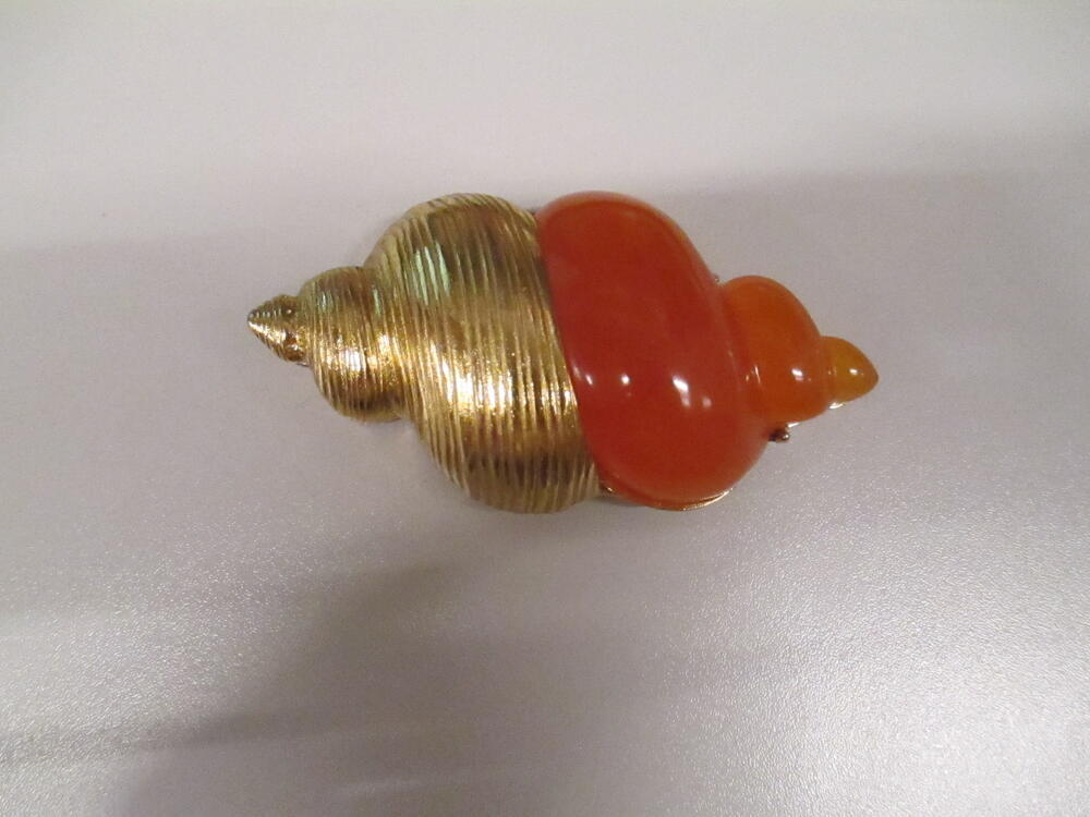 Pendantbroche in de vorm van schelp, verguld metaal en oranje hars
