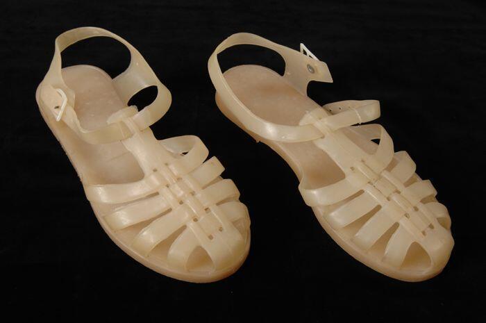 Ivoorkleurige plastic sandaal met gespsluiting en geprofileerde zool