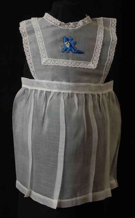 Babyjurk, mouwloos schortmodel van transparant wit nylonmet geborduurd blauw poesje, 'Femifra'…