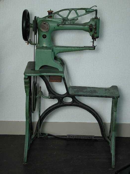 Groengeverfde metalen Singer-naaimachine op onderstel, gebruikt door schoenmaker