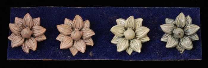 Twee paar oorbellen, clip met metalen bloem, geverfd in lichtgeel en roze, op blauw fluweelkarton,…