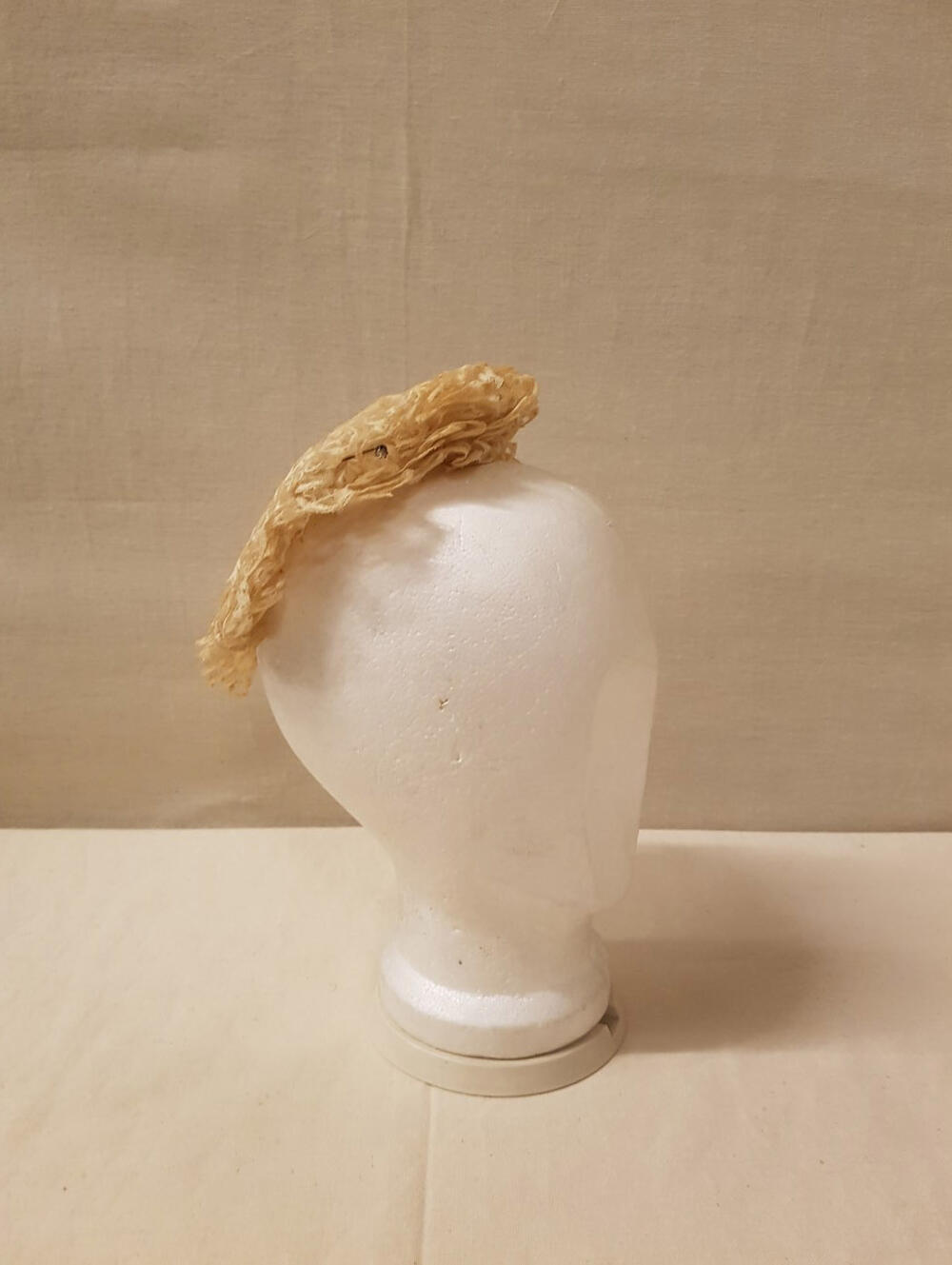 Coiffure / Kap, geheel bestaande uit stroken crèmekleurig geschulpt machinekant. 4 sierspelden met…