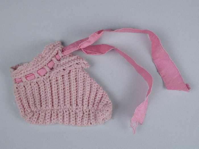 Paar babysloffen gehaakt van roze wol roze zijdelint door de enkel geregen