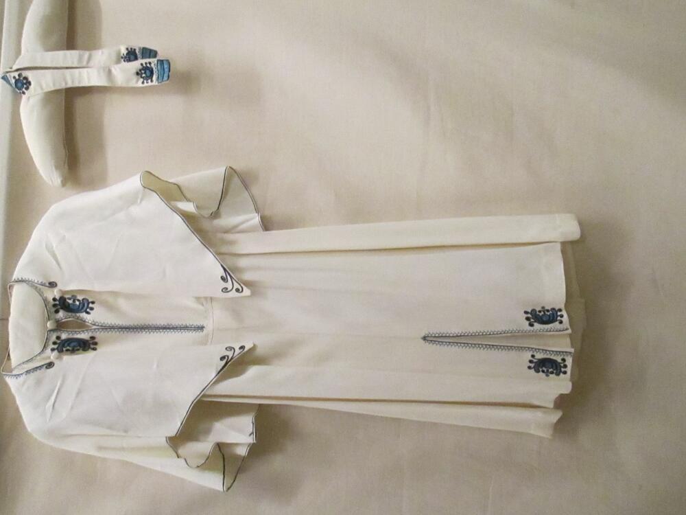 Jurk met schoudercape en ceintuur van wit synthetische stof met ingeweven zigzag, versierd met…