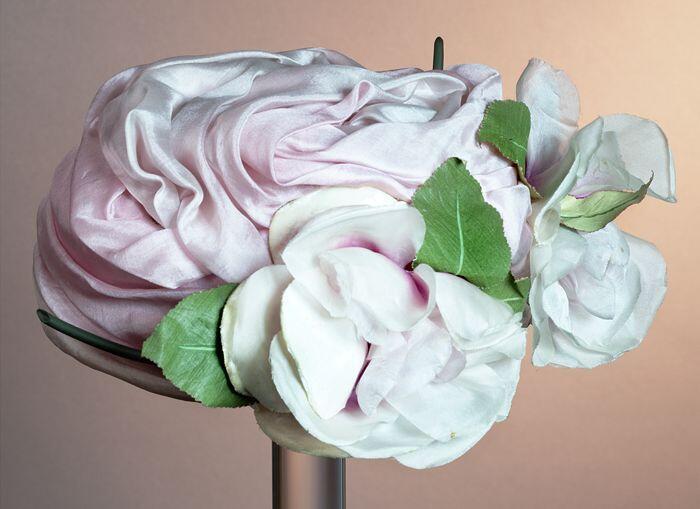 Dameshoed van gedrapeerde roze zijde garnering van twee grote rozen van zijde katoenen fluweel