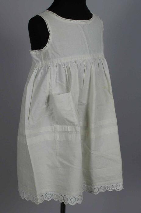 Kinderonderjurk, rechte pas met aangerimpeld rokdeel met (later) opgestikte zak, broderie langs…