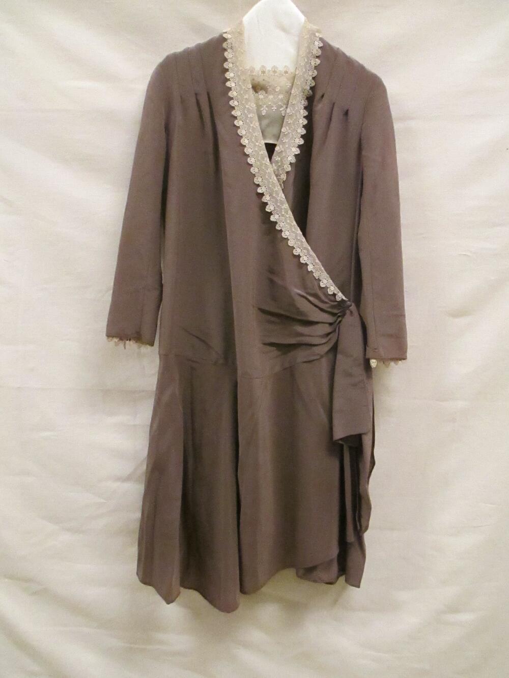 Jurk van lichtbruine ottomanzijde, gegarneerd met beige crêpe georgette, machinaal kant en…