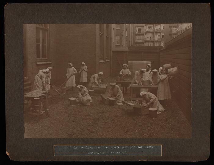 Grote zwart-wit foto geplakt op matzwart karton, met klas van de School voor Vrouwenarbeid,…