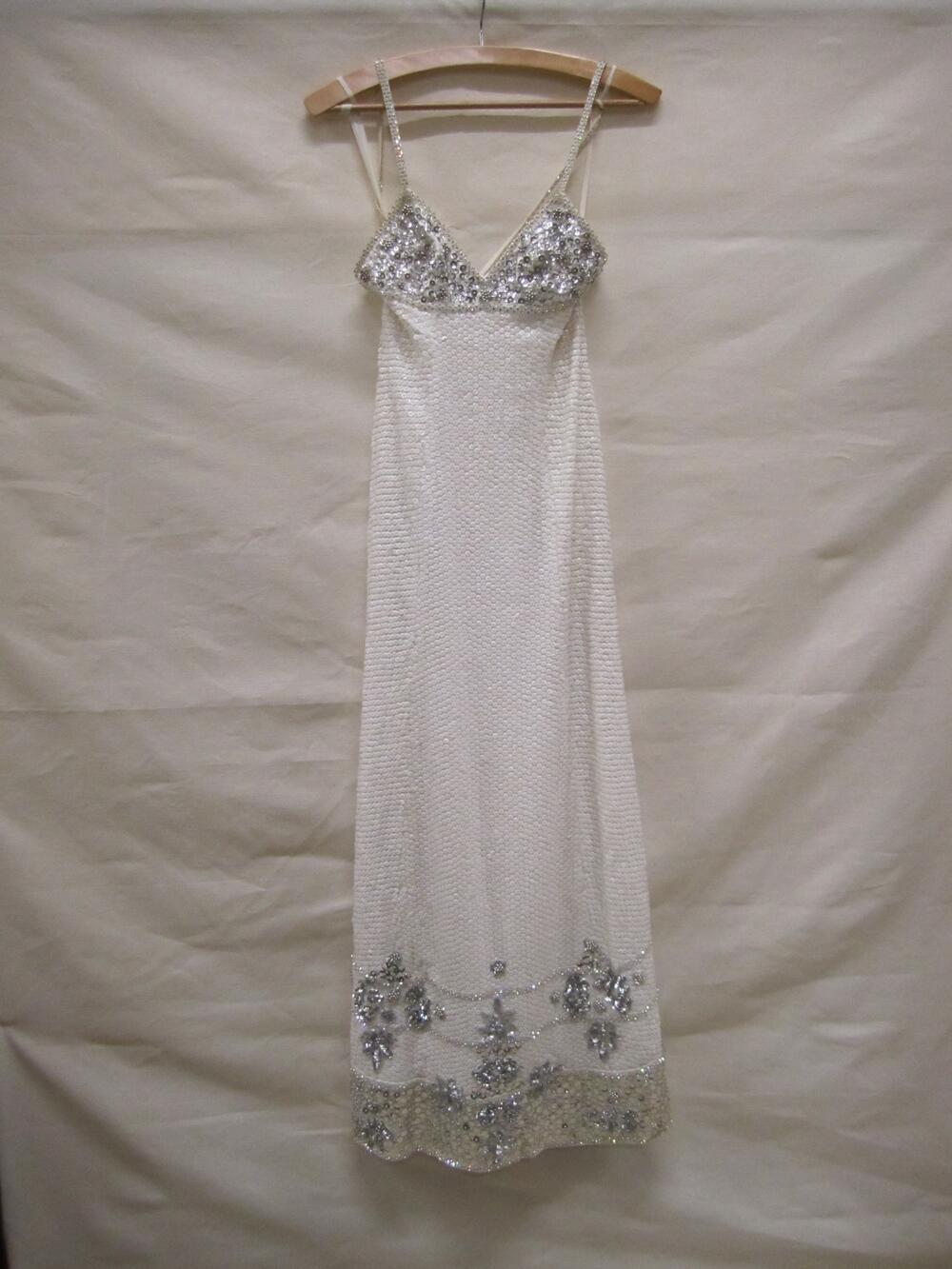 Avondjurk van wit zijden organza geheel bestikt met witte pailletten en deels met zilveren…