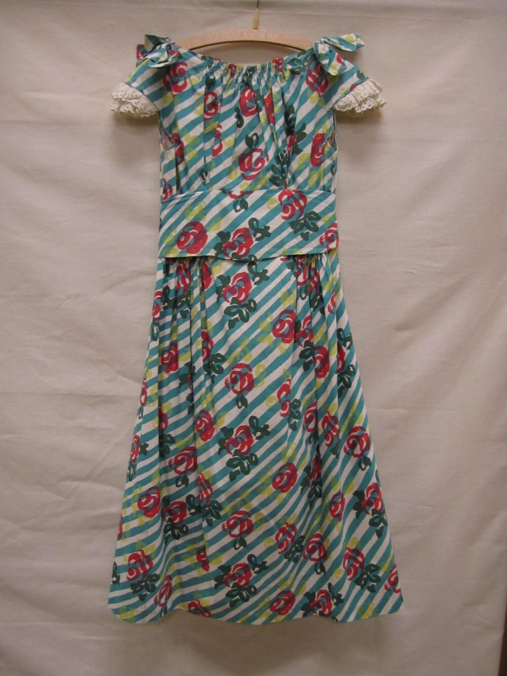 Zomerjurk van wit katoen bedrukt met diagonale turquoise streep, en geabstraheerd rozenmotief in…