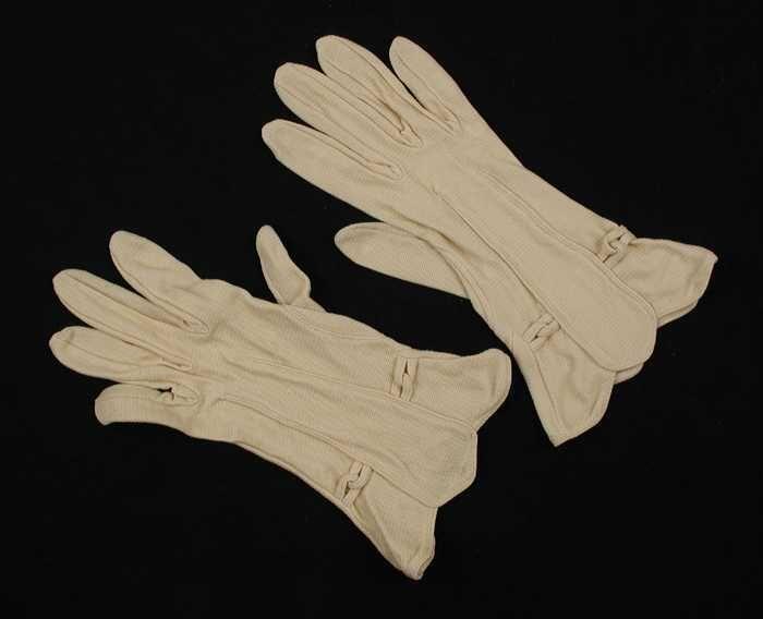Paar korte dameshandschoenen van crèmekleurig tricot, sierdeel op de rug
