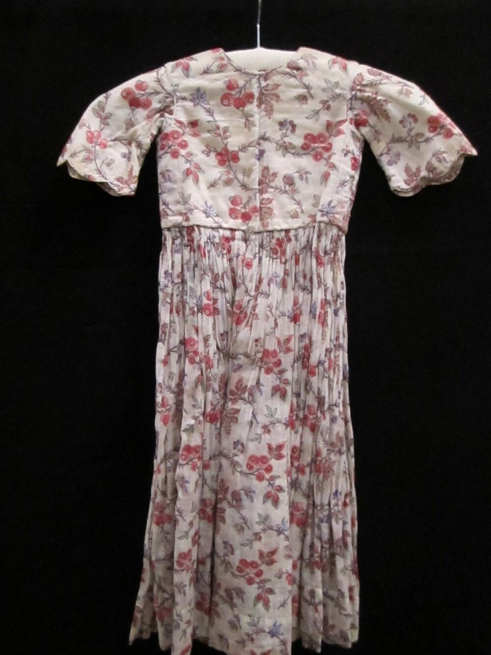Jurk (kind) van dun wit katoen bedrukt met bloemtakjes in paars, blauw, rood, roze, groen