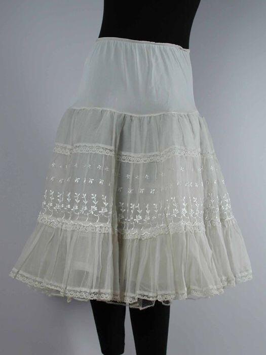 Witte nylonpetticoat, bestaande uit bovenlaag van organza met wit geborduurde bloemetjes, tweede…