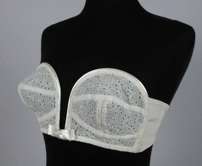 Witte strapless bustehouder met opengewerkt bloemmotief, diep decolleté, beugels over de borst,…