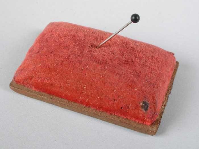 Rechthoekig rood speldenkussen met kopspeld