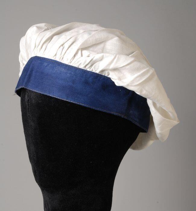 Muts, wit katoenen bol gerimpeld aan een blauwe katoenen band