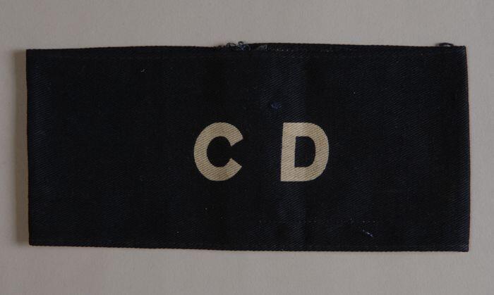Mouwband van donkerblauw keperkatoen met in grijze letters "CD"