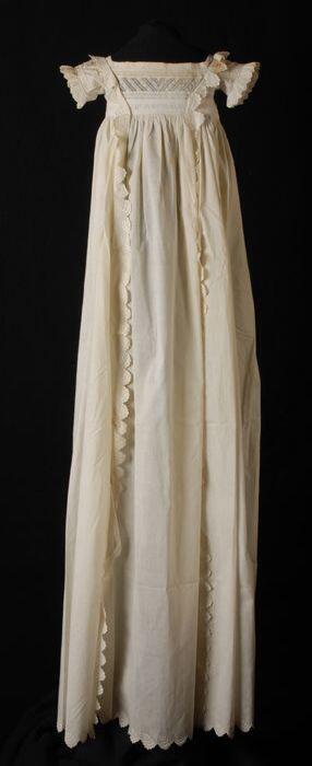 Ecru doopjurk, bovenlijfje van broderie, twee verticale broderie stroken doorlopend tot over de…