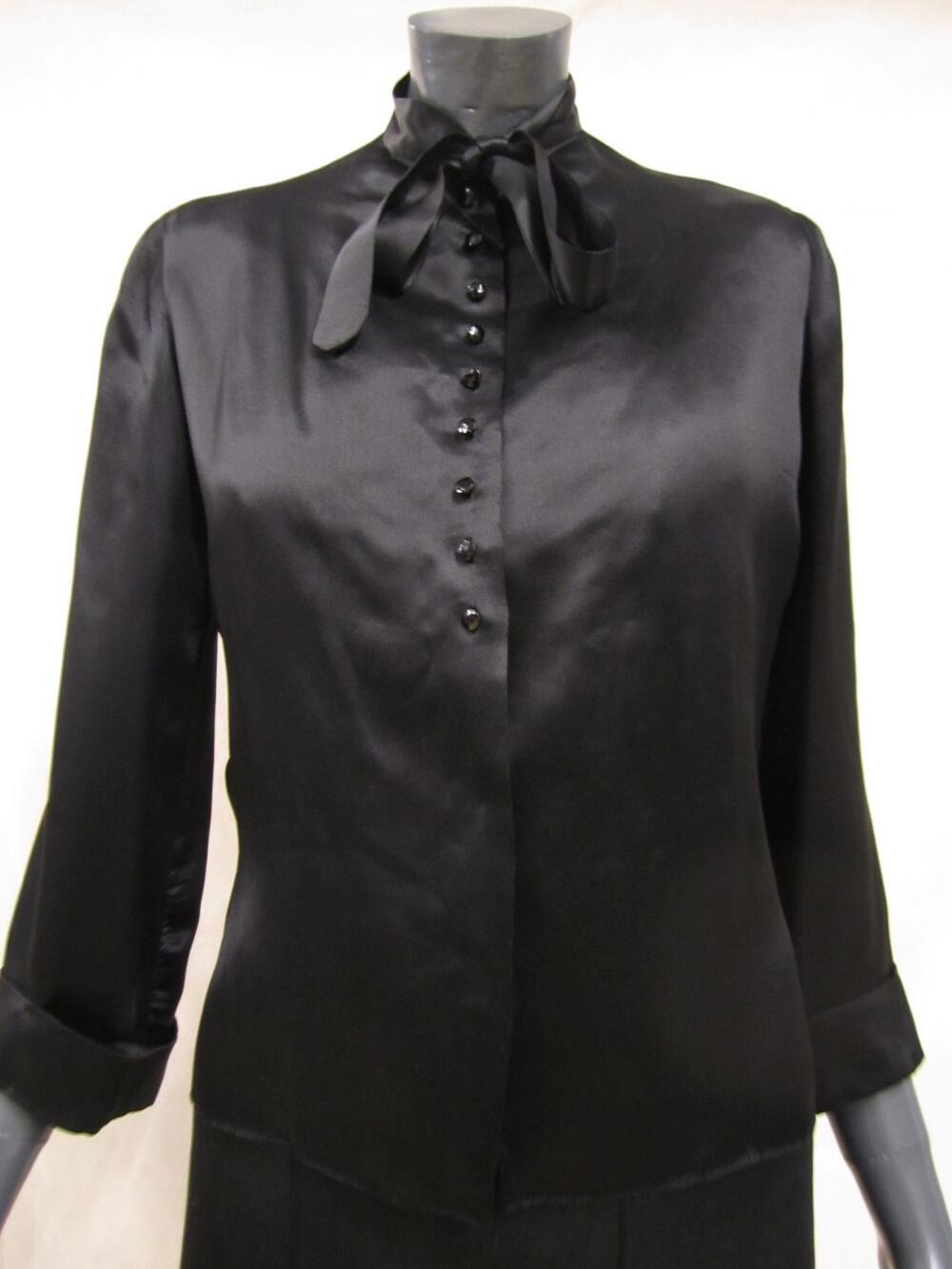 Blouse van zwart zijden satijn met aangenaaid striklint aan de kraag en knoopjes van gefacetteerd…