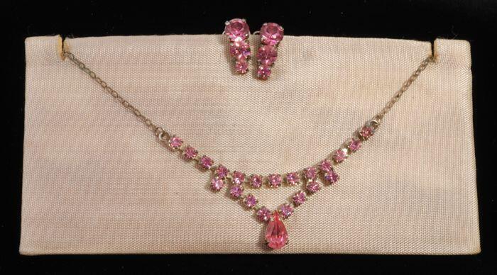 Halsketting (A) en bijbehorend paar oorclips (B-C) beiden met roze kunstdiamantjes in…