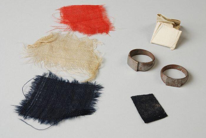 Twee ringen (A-B), drie stukjes vlag (C-E) en één stukje uniform (F) van Jan van Speijk