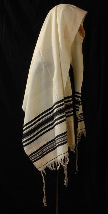 Joodse gebedssjaal of tallit katan, brede crèmekleurige wollen lap met ingeweven zwarte banen en…