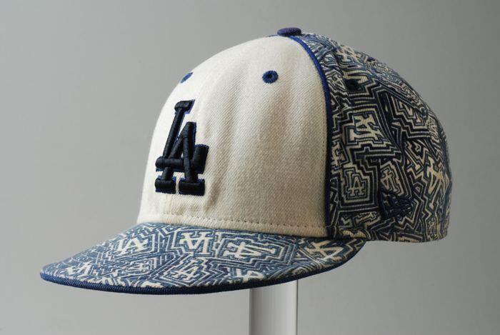 Pet met letters "LA" op de voorkant, kleuren wit en blauw, merk "New Era"