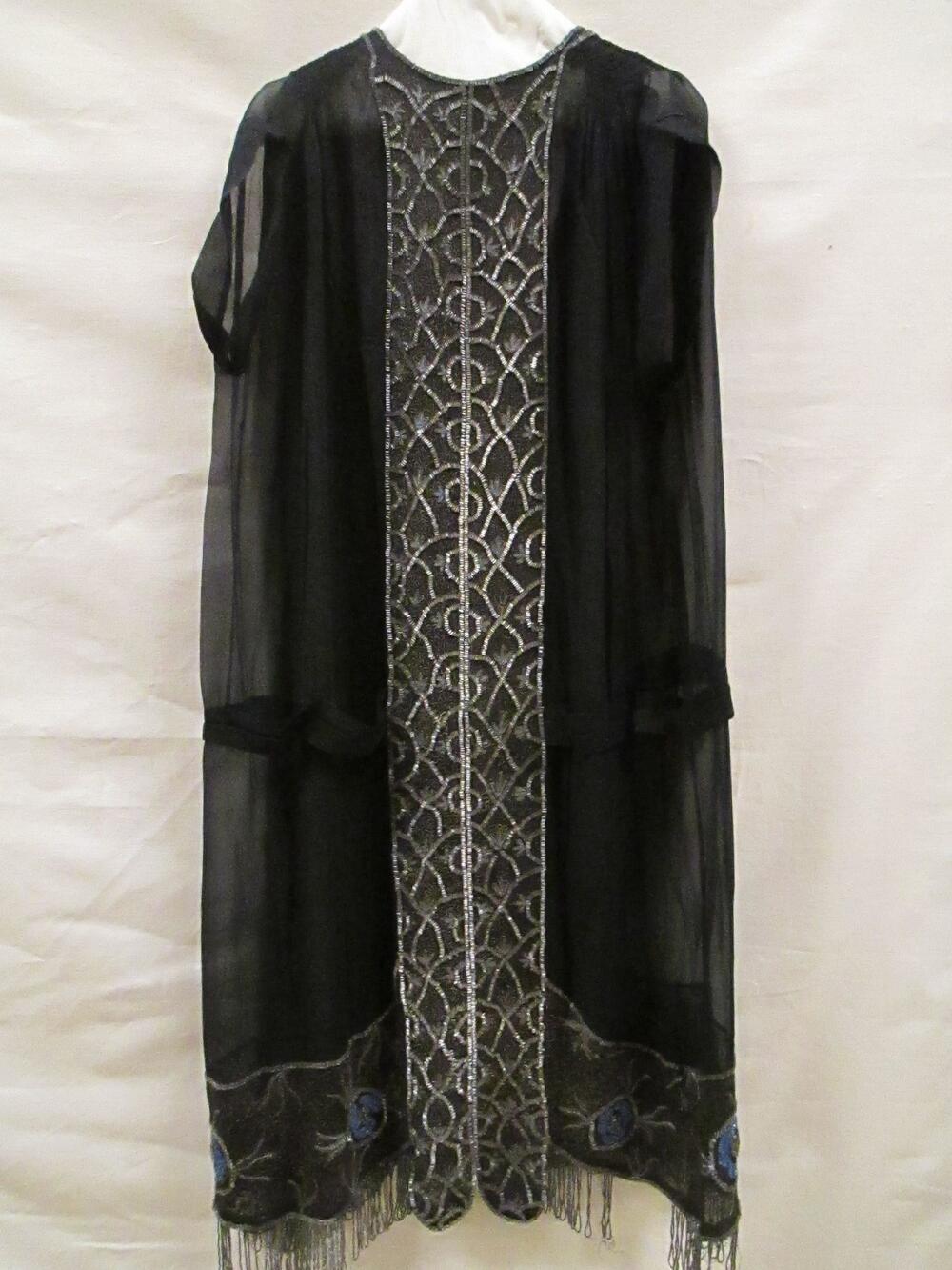 Avondjurk van zwarte crêpe georgette, gegarneerd met zilverkleurige glaskralen, gouddraad en blauw…