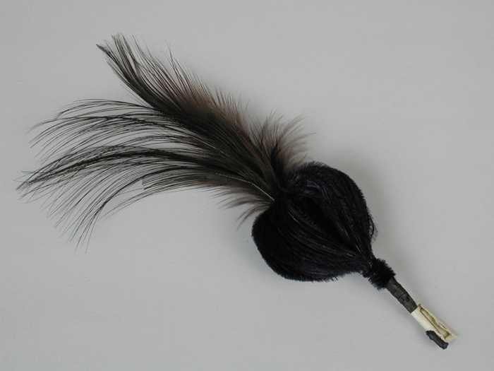 Veren hoedendecoratie of corsage, donkerblauwe maraboeveren omgezet rond toefje donkerbruine…