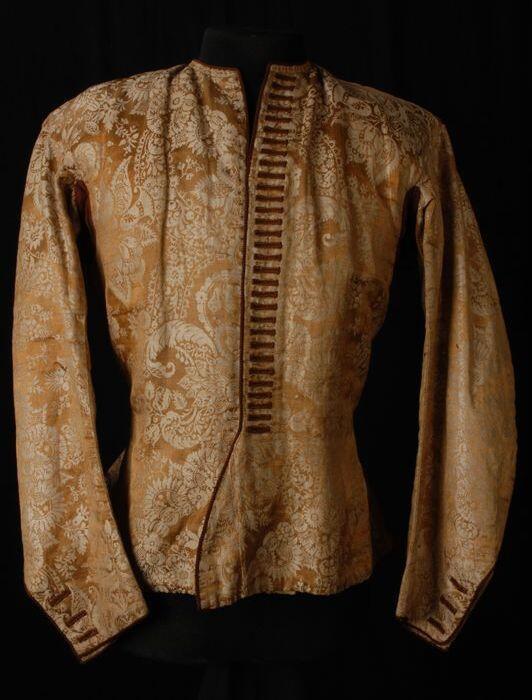 Herenvest van goud-beige halfzijde damast of brokaat met patroon van bloemen en arabesken afgewerkt…