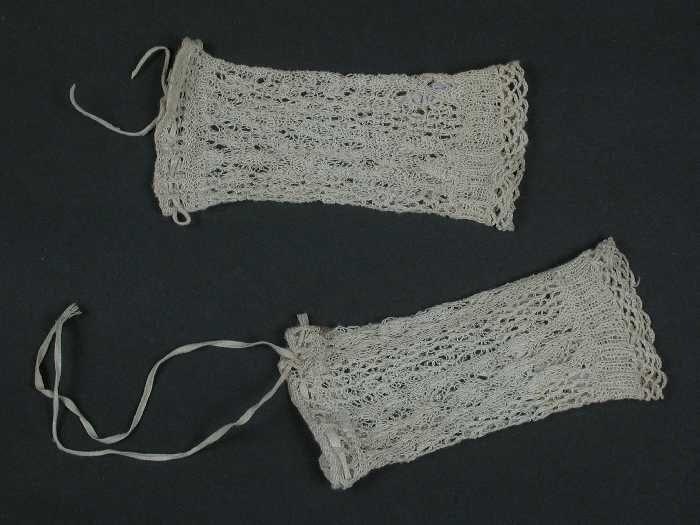 Paar korte ondermouwen van fijn crèmekleurig katoenen garen, gebreid in ajour, babykleding
