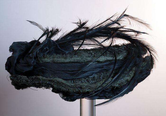 Ronde zwarte dameshoed, rouwkleding, gaas met platte veren, garnering van zwart lint rond bol