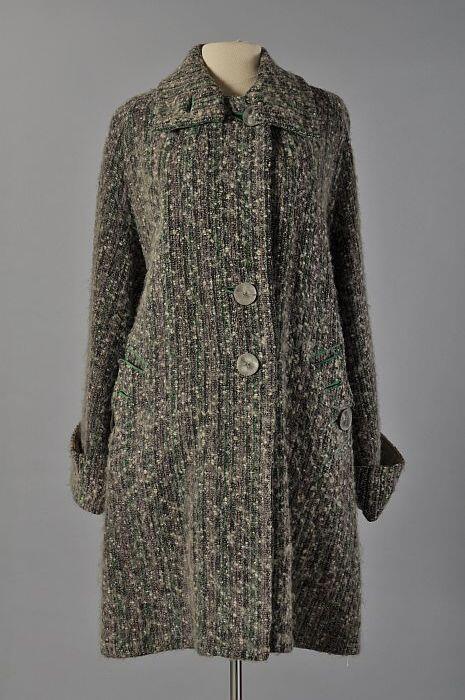 Knielange damesmantel van zwart en wit wollen tweed met groene en lila banen, groene belijning