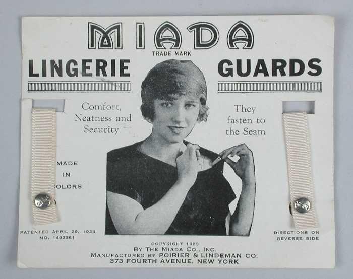 Paar lingeriehouders van roze zijdesatijn op een kartonnen kaartje "Miada / lingerie guards"