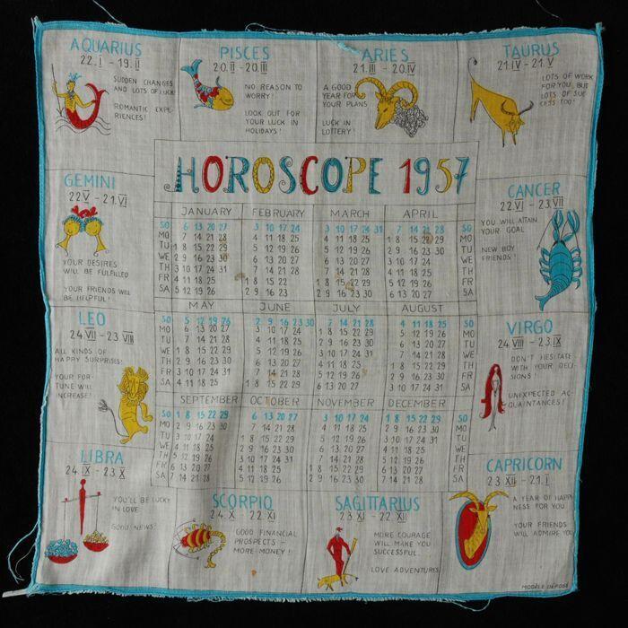 Vierkante wit katoenen zakdoek met opdruk in rood, blauw, geel en zwart, centraal jaarkalender 1957…