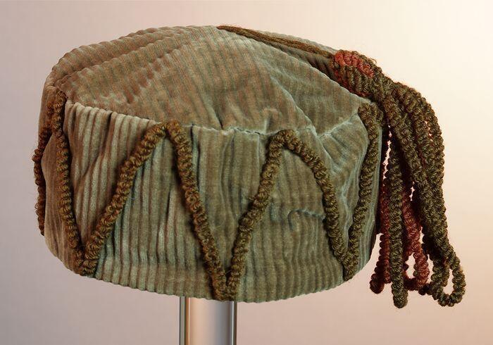 Ronde bruin ribfluwelen fez, huismuts, smoking cap met kwast in rood en bruin