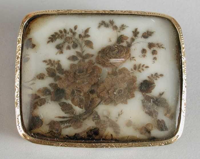 Bewerkt gouden broche met haartukje