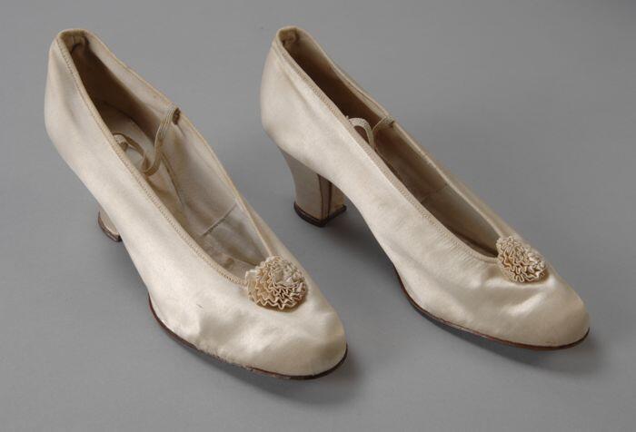 Roomwitte satijnen hakschoenen (bruidsschoenen) met rozetje van geplooid satijn bovenop, elastiek…