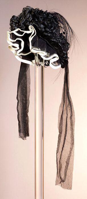 Zwarte ronde dameshoed, rouwkleding, met opbollende versiering en veren, strass-steentjes op…