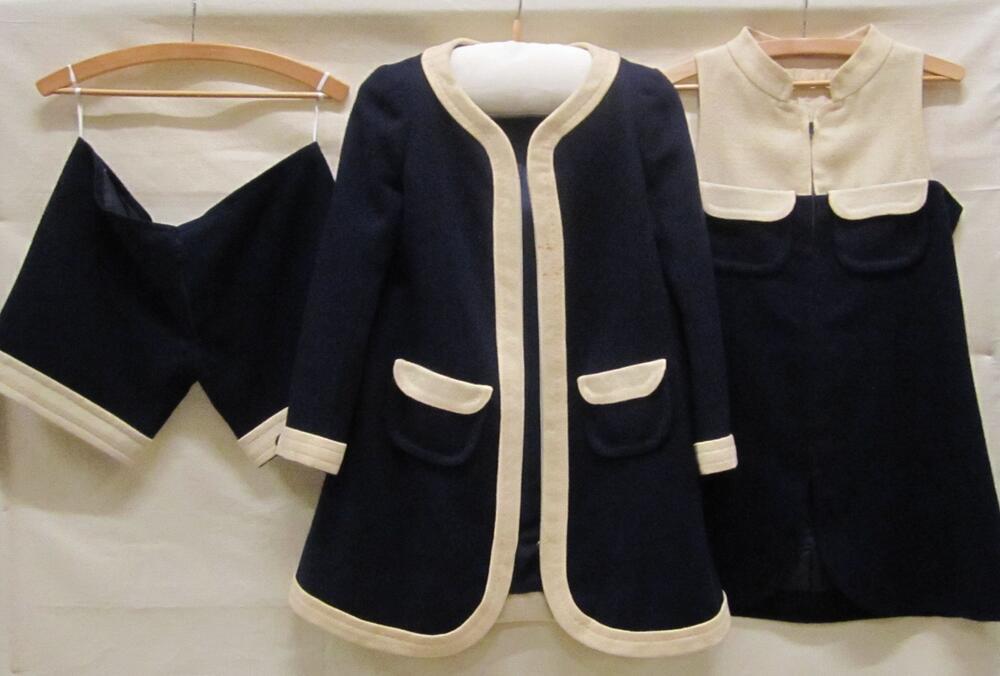 Broekpak van donkerblauwe en witte wol bestaande uit een jasje, shorts of korte broek en een tuniek