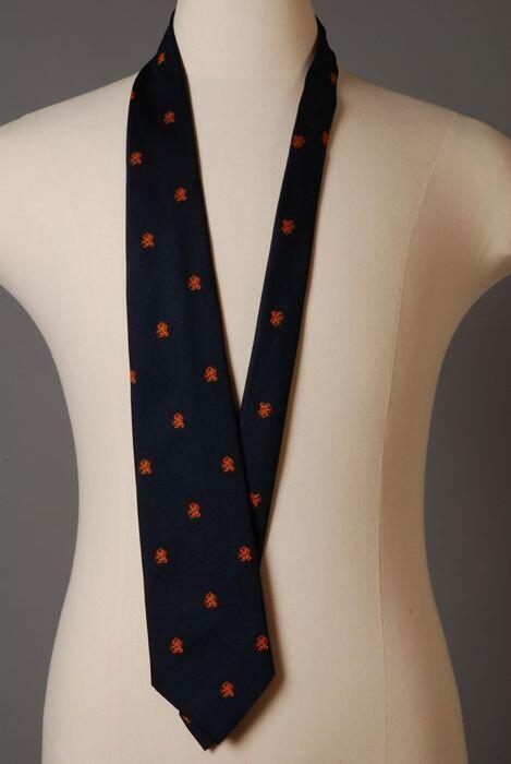 Stropdas van donkerblauw zijde met kleine ingeweven oranje Nederlandse leeuw, "stichtin voor…