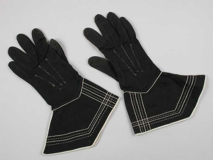 Paar korte dameshandschoenen van zwart tricot katoen met brede manchetten met witte stiksels en…