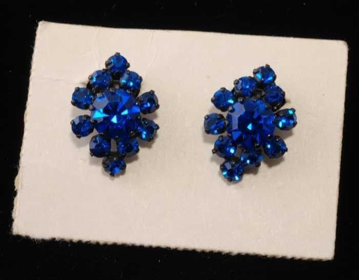 Paar oorbellen, zwart metalen clip met blauwe kunstdiamantjes, op kartonnetje, kapper Van Vliet