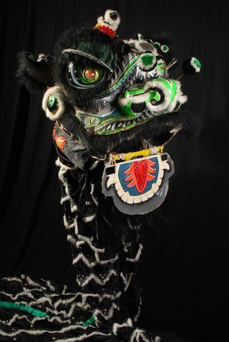 Fantastische kop van een Chinese leeuw, van metaal en papier maché, zwart en groen met elektrisch…