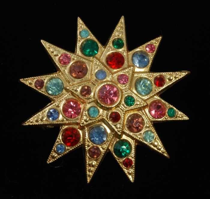 Broche van goudkleurig metaal, 12-puntige met gekleurde kunstdiamantjes, kapper Van Vliet