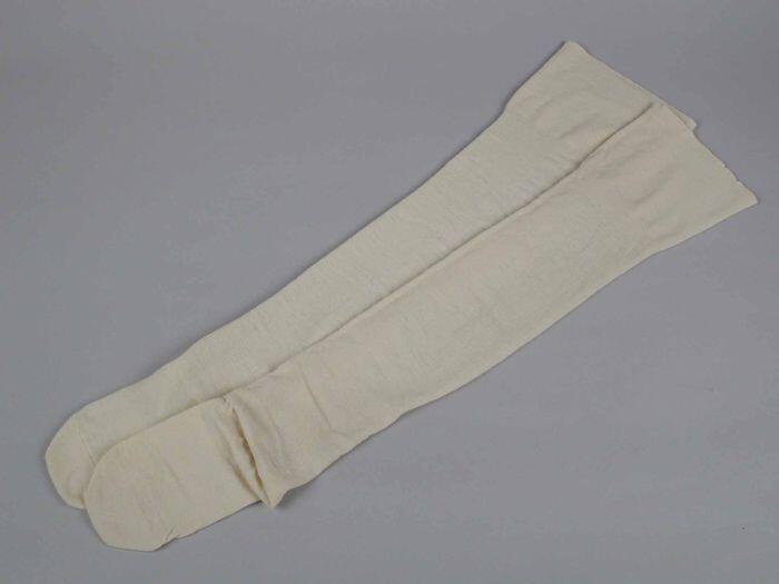 Paar lange kousen van crèmekleurige fijne tricot wol