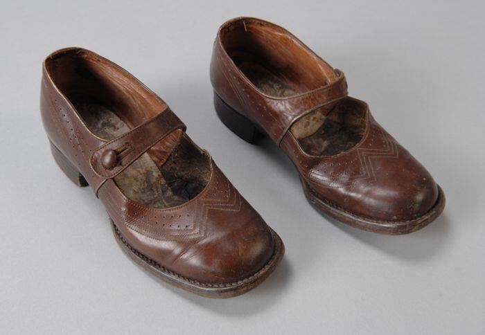 Paar bruine leren meisjesschoenen met wreefbandje met knoopsluiting en sierstiksels en…
