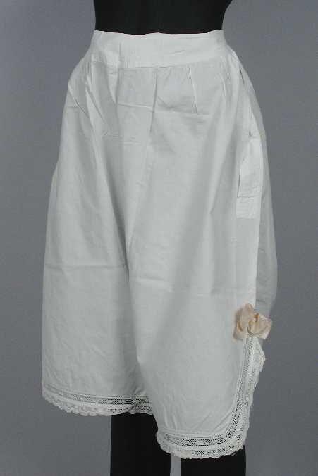 Witte onderbroek met lange pijpen met splitjes aan de zijkant, afgezet met kant en twee zalmroze…
